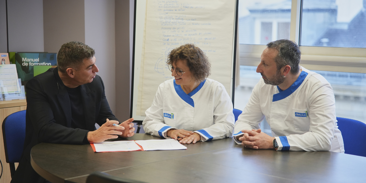 Deux franchisés dietplus signent leur contrat avec le président du réseau.